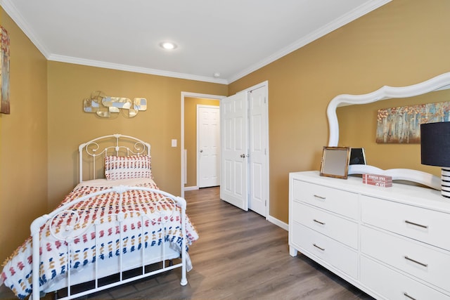 bedroom with crown molding, dark wood-type flooring, and a closet