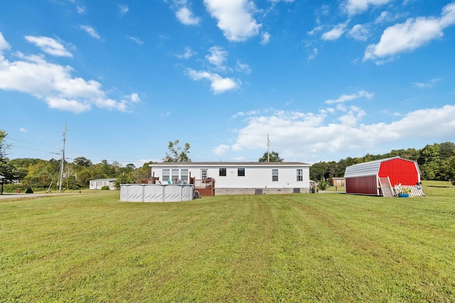 back of property featuring a yard and a storage unit