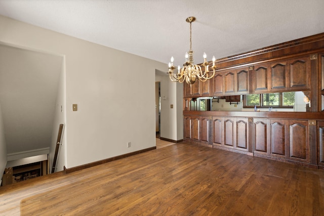 kitchen featuring hanging light fixtures, dark wood-type flooring, and a chandelier