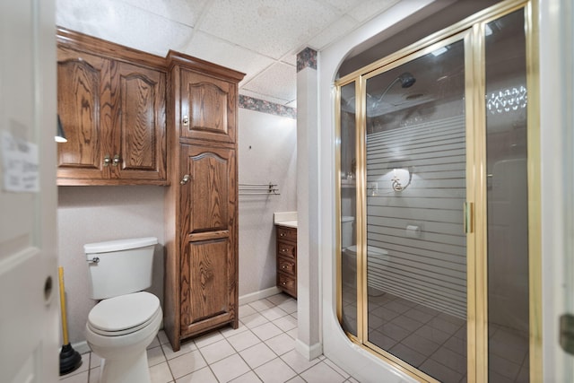 bathroom with tile patterned flooring, vanity, a shower with shower door, and toilet