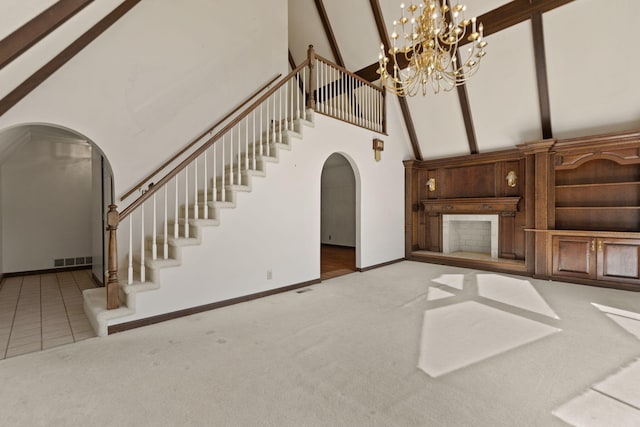 unfurnished living room featuring beamed ceiling, high vaulted ceiling, light carpet, and a notable chandelier