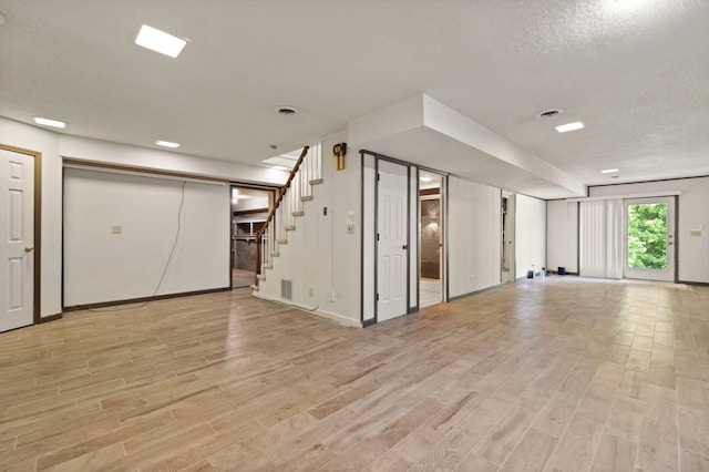 basement with a textured ceiling and light wood-type flooring