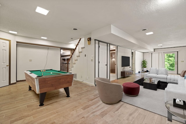 playroom with billiards, a textured ceiling, and light wood-type flooring