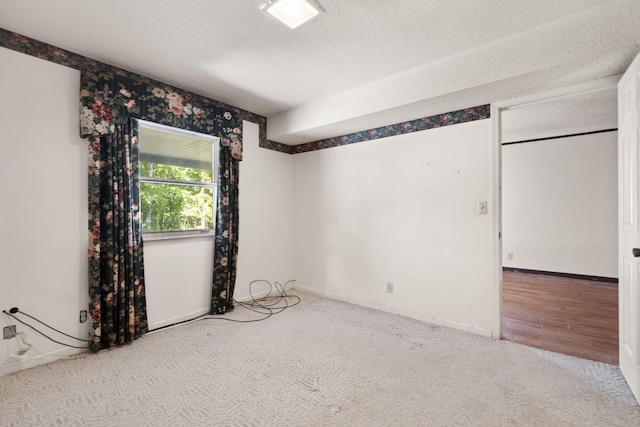 spare room with a textured ceiling and carpet