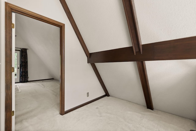 staircase with carpet floors and vaulted ceiling with beams