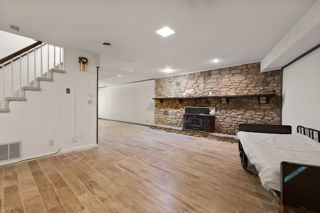 unfurnished living room featuring light hardwood / wood-style flooring and a wood stove