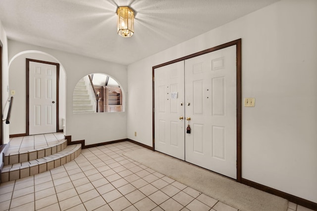 tiled entrance foyer featuring a textured ceiling