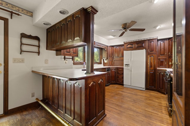 kitchen featuring ceiling fan, white fridge with ice dispenser, a textured ceiling, dark hardwood / wood-style flooring, and kitchen peninsula