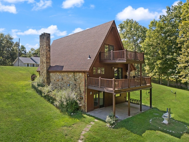 back of house featuring a wooden deck, a yard, and a patio area