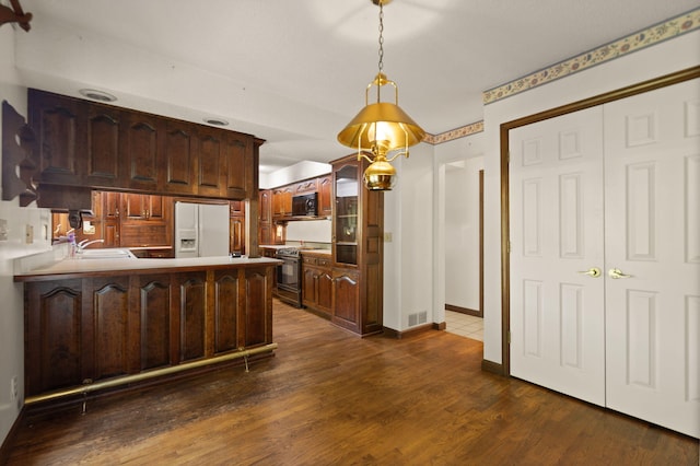 kitchen featuring dark wood-type flooring, dark brown cabinetry, range, and white fridge with ice dispenser