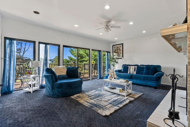 living room featuring dark carpet and ceiling fan