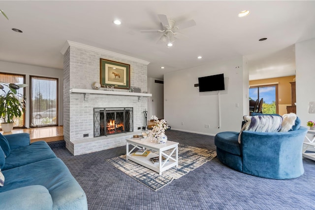 carpeted living room with a wealth of natural light, ceiling fan, and a fireplace