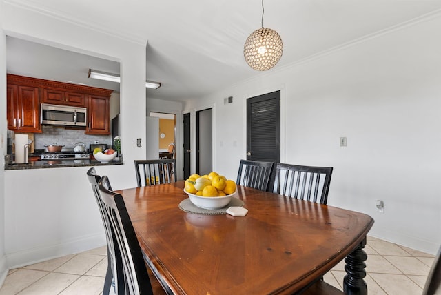 dining space with a notable chandelier, light tile patterned flooring, and ornamental molding