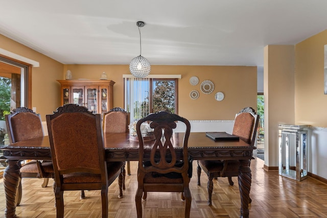 dining room featuring an inviting chandelier and parquet flooring