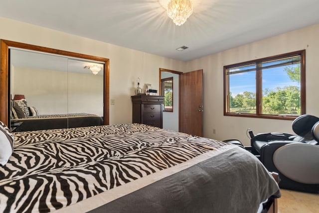 bedroom with multiple windows, a notable chandelier, and a closet