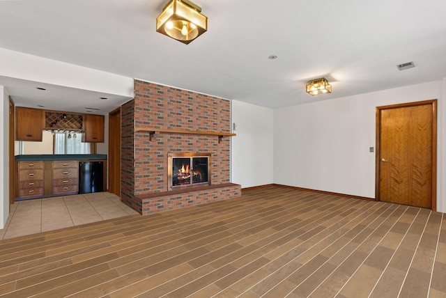 unfurnished living room featuring hardwood / wood-style flooring and a fireplace