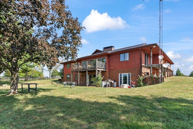 rear view of property featuring a lawn