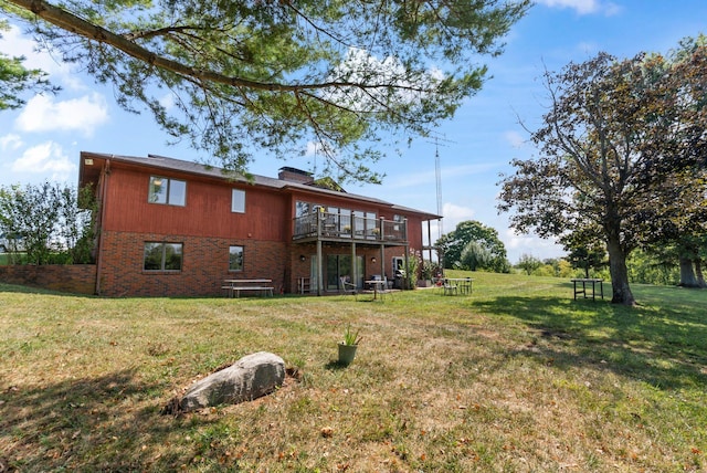 rear view of property featuring a lawn and a deck