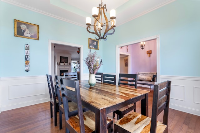 dining area featuring ceiling fan with notable chandelier, dark hardwood / wood-style flooring, and crown molding