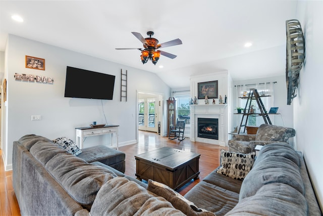 living room featuring ceiling fan, light hardwood / wood-style floors, and vaulted ceiling