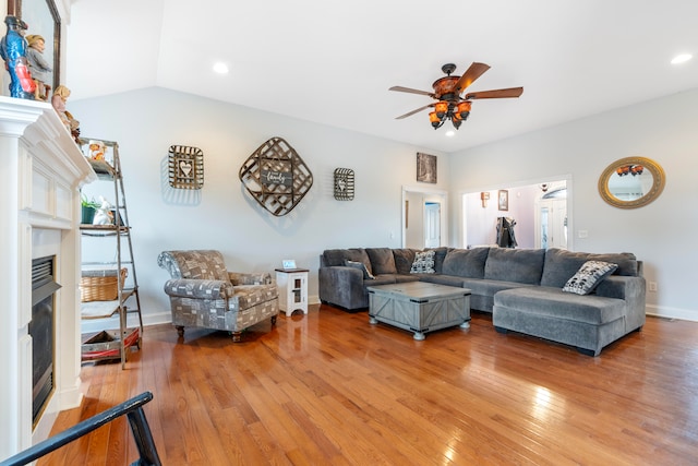 living room with ceiling fan, hardwood / wood-style flooring, and vaulted ceiling