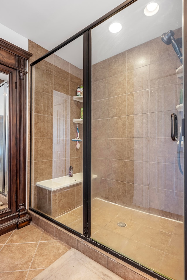 bathroom with an enclosed shower and tile patterned flooring