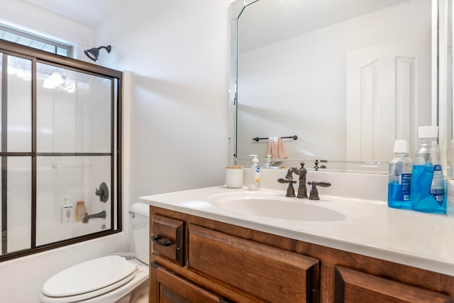 full bathroom with combined bath / shower with glass door, vanity, and toilet