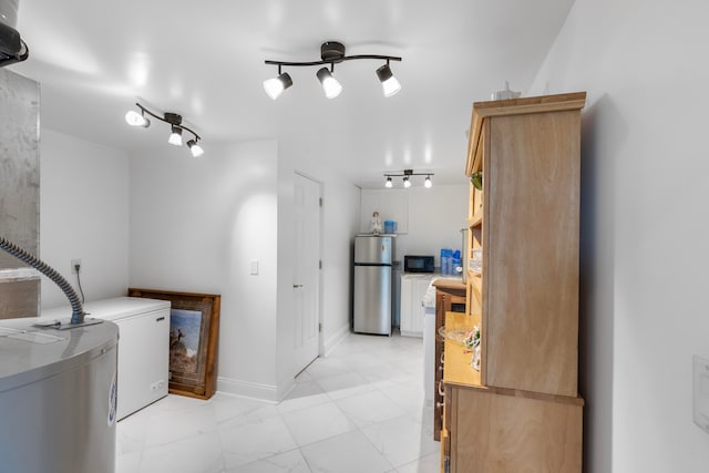 kitchen with stainless steel refrigerator and washing machine and dryer