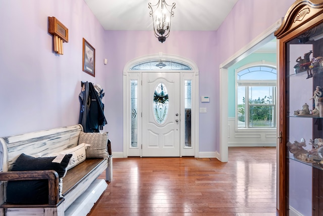 foyer entrance with hardwood / wood-style flooring and an inviting chandelier