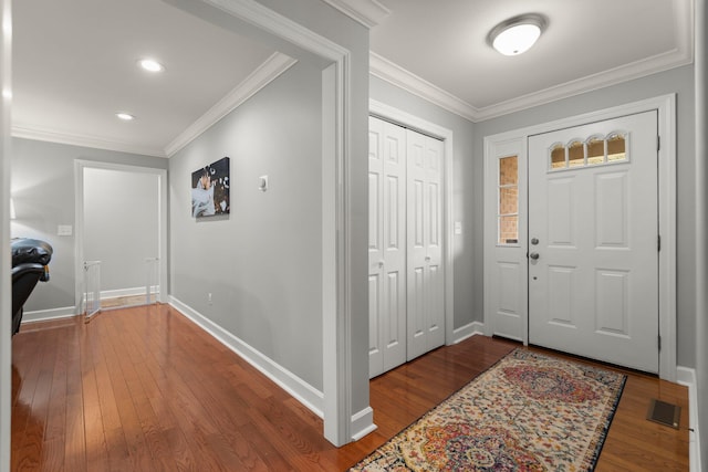 foyer with ornamental molding and hardwood / wood-style floors