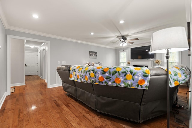 living room featuring ceiling fan, hardwood / wood-style flooring, crown molding, and a healthy amount of sunlight