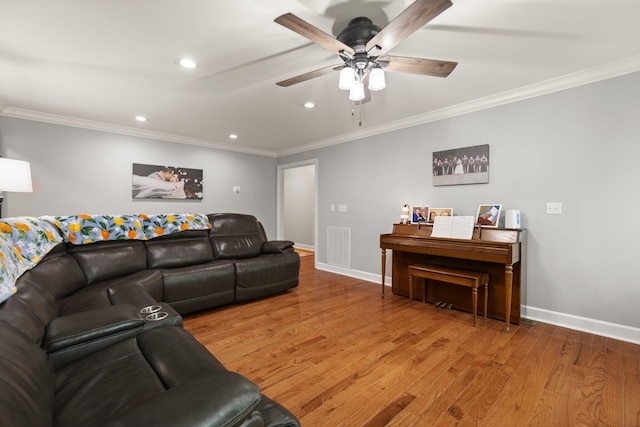 living room featuring ornamental molding, wood-type flooring, and ceiling fan