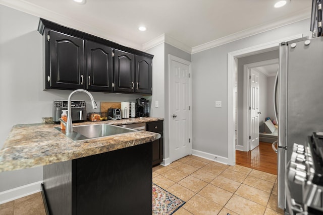 kitchen with ornamental molding, stainless steel fridge, light hardwood / wood-style flooring, and sink