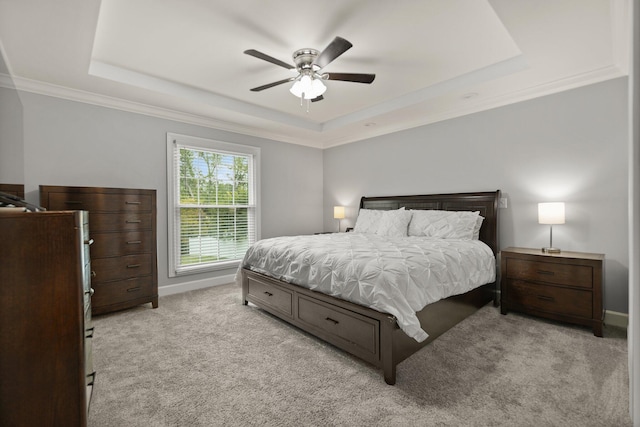 bedroom featuring a raised ceiling, ceiling fan, ornamental molding, and light carpet