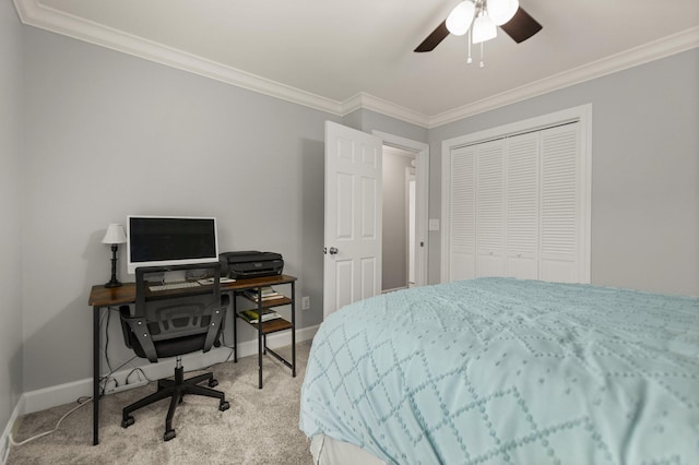 carpeted bedroom with ceiling fan, ornamental molding, and a closet