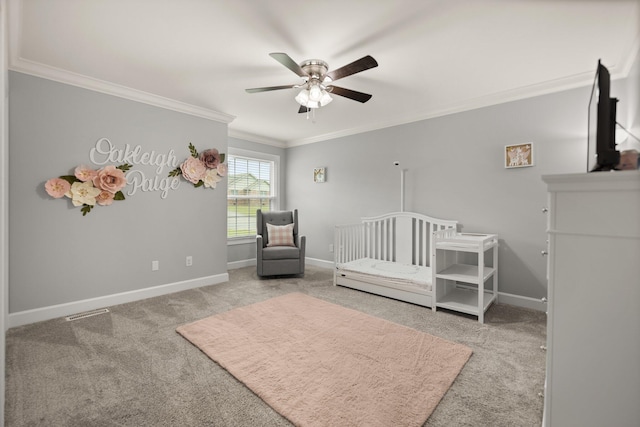 unfurnished bedroom with carpet flooring, ceiling fan, a nursery area, and crown molding