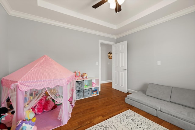 interior space with crown molding, a raised ceiling, hardwood / wood-style flooring, and ceiling fan