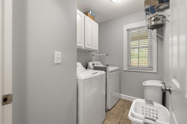 laundry area with cabinets, independent washer and dryer, and light tile patterned flooring