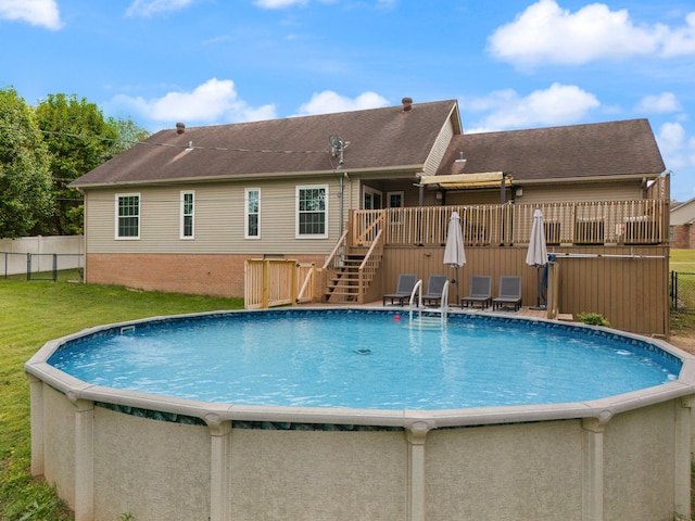 view of pool featuring a lawn and a deck