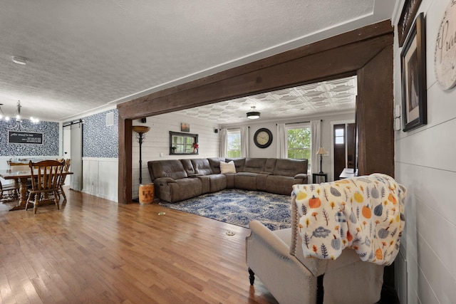 living room featuring a textured ceiling, hardwood / wood-style flooring, and a notable chandelier