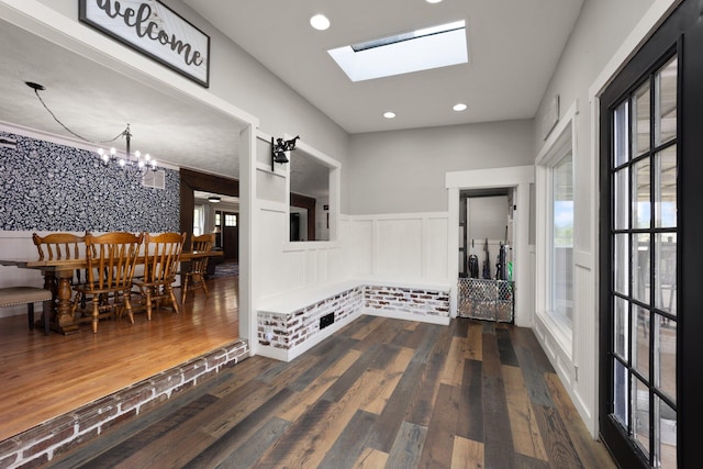 hallway featuring a wealth of natural light, a chandelier, and dark hardwood / wood-style floors