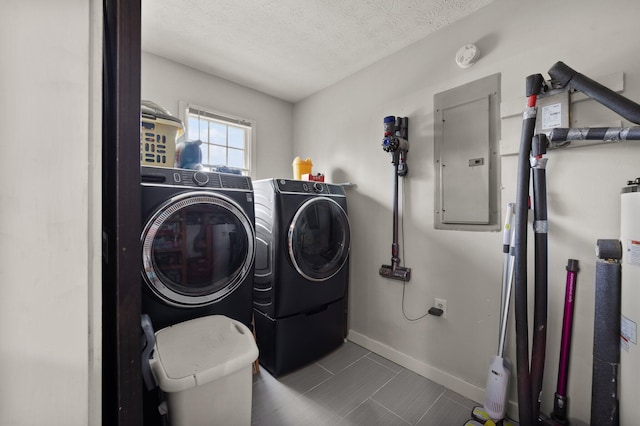 laundry room with a textured ceiling, washer and clothes dryer, and electric panel