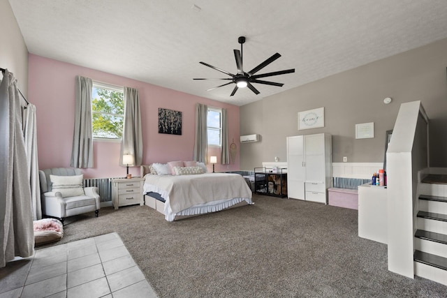 carpeted bedroom featuring ceiling fan, radiator heating unit, an AC wall unit, and a textured ceiling