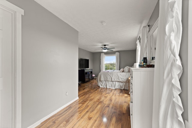 bedroom featuring a textured ceiling, ceiling fan, and hardwood / wood-style floors