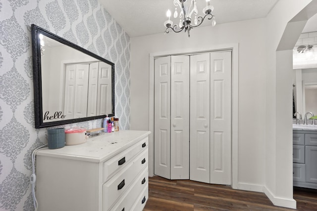 interior space featuring dark hardwood / wood-style flooring, a chandelier, sink, and a textured ceiling