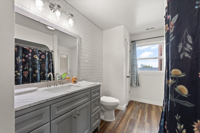 bathroom with wood-type flooring, toilet, and vanity