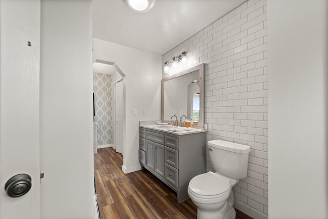 bathroom with wood-type flooring, toilet, and vanity