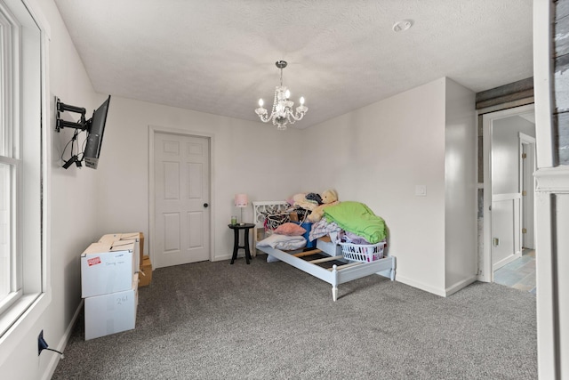 interior space with a chandelier, a textured ceiling, and carpet floors