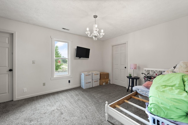 carpeted bedroom with a textured ceiling and a chandelier