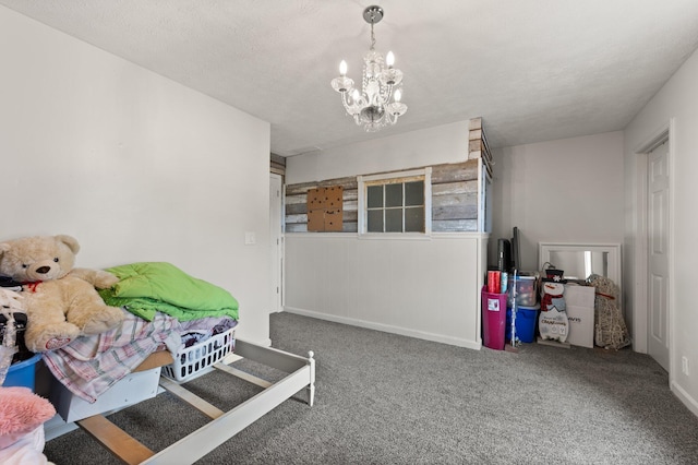 bedroom with a textured ceiling, carpet, and an inviting chandelier